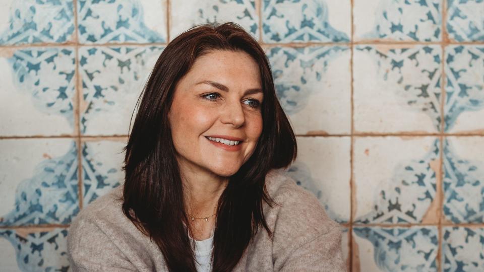 Woman sitting on the ground in jeans against pretty tiles