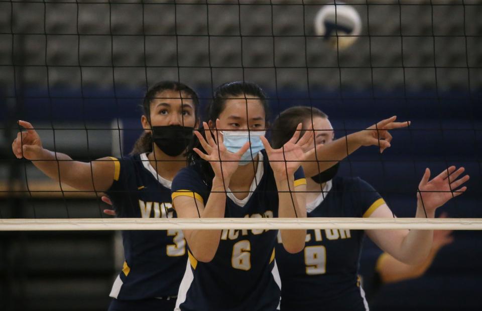 Victor's Alex McKenzie (3), left, Helen Qian (6), center, and Emily Willow (9), right, set up the net as they ready for a Victor serve during their Section V Class AA championship finals match up Saturday, Nov. 6, 2021 at Gates Chili High School. 