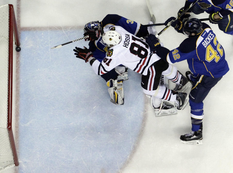 Chicago Blackhawks' Marian Hossa (81), of Slovakia, scores past St. Louis Blues goalie Ryan Miller and David Backes (42) during the first period in Game 5 of a first-round NHL hockey playoff series Friday, April 25, 2014, in St. Louis. (AP Photo/Jeff Roberson)