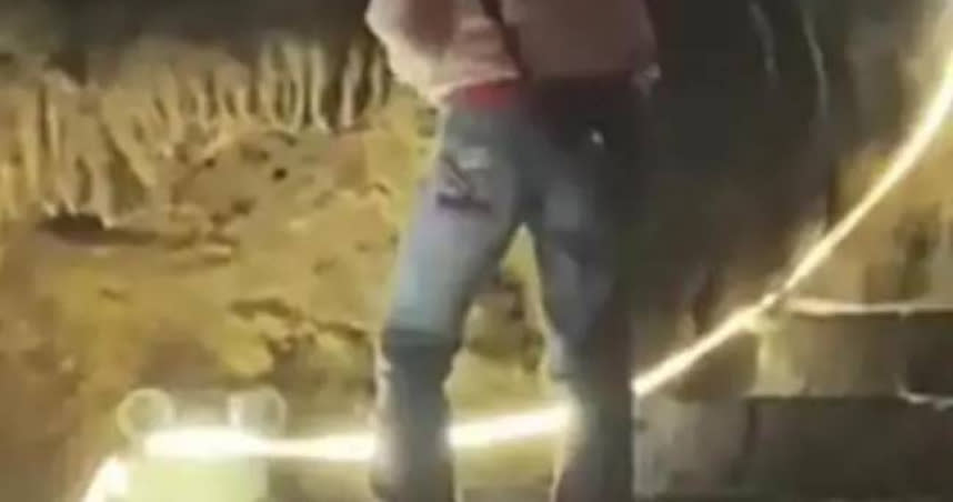 大陸網友近日發布一段男孩用磚頭敲鐘乳石被勸阻的視頻。（圖／翻攝自微博）