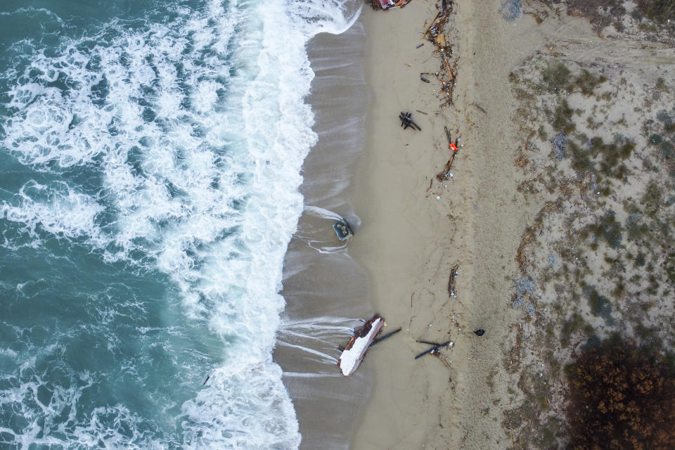 A view of part of the wreckage of a capsized boat that was washed ashore at a beach near Cutro, southern Italy, Monday, Feb. 27, 2023. Rescue crews searched by sea and air Monday for the dozens of people believed still missing from a shipwreck off Italy’s southern coast that drove home once again the desperate and dangerous crossings of migrants seeking to reach Europe. (AP Photo/Luigi Navarra)