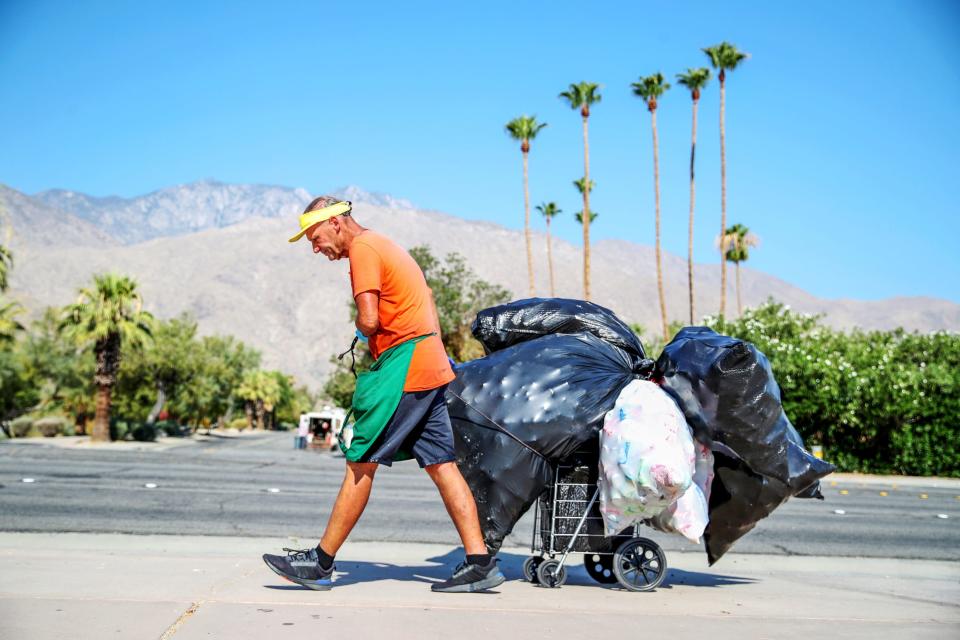 Retired veteran Lawrence Sing, 66, of Desert Hot Springs pulls a haul of recyclable bottles and cans to redeem for supplemental income in Palm Springs, Calif., on Tuesday, July 9, 2024. "I'm a jock. You've got to acclimate to this heat. This is just like running or exercising," said Sing, who works until noon, 3-5 days a week recycling.