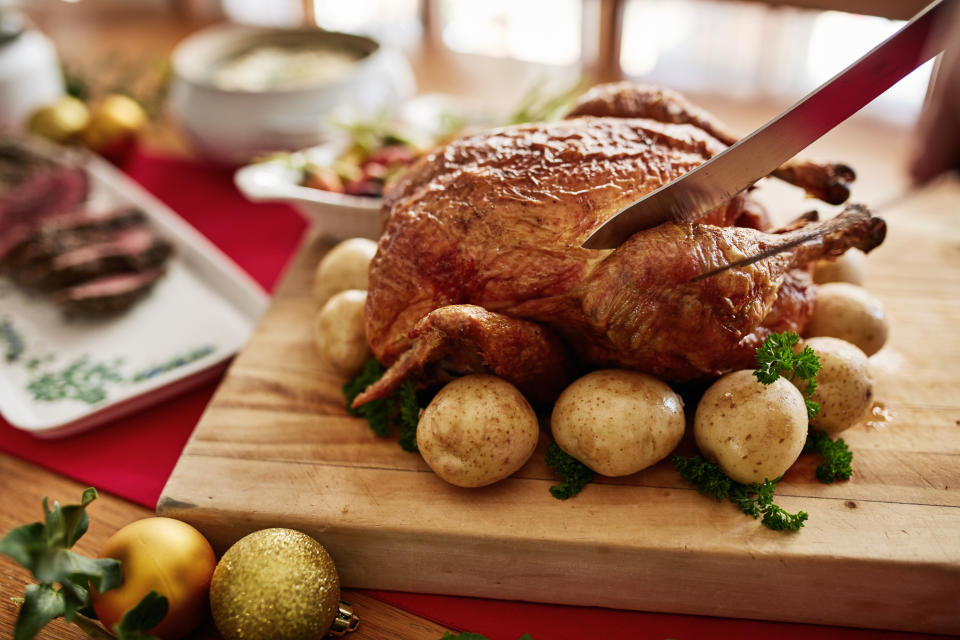 Chicken, meat and christmas food on a table for a family celebration dinner with decoration. Healthy potato, turkey and produce luxury holiday feast prepared for event in a dining room at home.