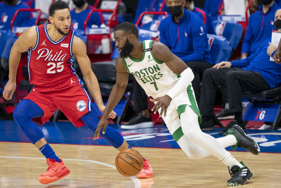 Boston Celtics' Jaylen Brown, right, drives to the basket against Philadelphia 76ers' Ben Simmons, left, during the first half of an NBA basketball game, Friday, Jan. 22, 2021, in Philadelphia. (AP Photo/Chris Szagola)