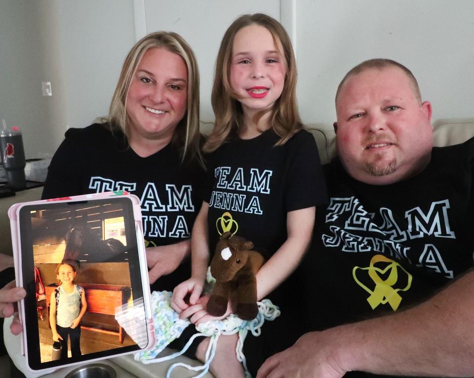 The Teachman family, from left, Kim, Jenna and Matt, Wednesday, Jan. 10, 2024, at their Port Orange home. Kim holds an iPad with a photo of Jenna and the horse she fell off which led to the discovery of Jenna having stage 4 pancreatic cancer.