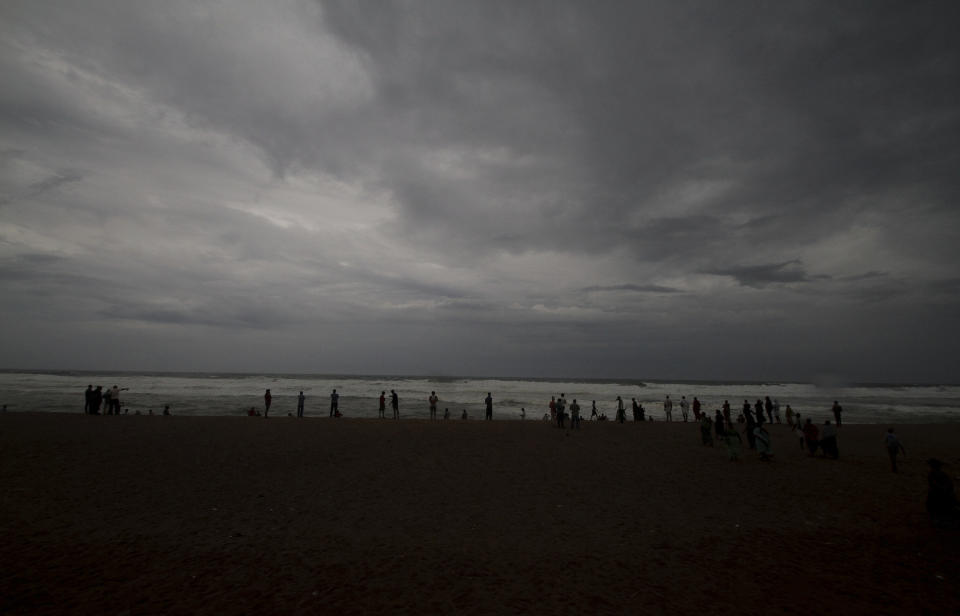 Dark clouds loom over locals standing at a beach in Puri district of eastern Odisha state, India, Thursday, May 2, 2019. Hundreds of thousands of people were evacuated along India's eastern coast on Thursday as authorities braced for a cyclone moving through the Bay of Bengal that was forecast to bring extremely severe wind and rain. (AP Photo)