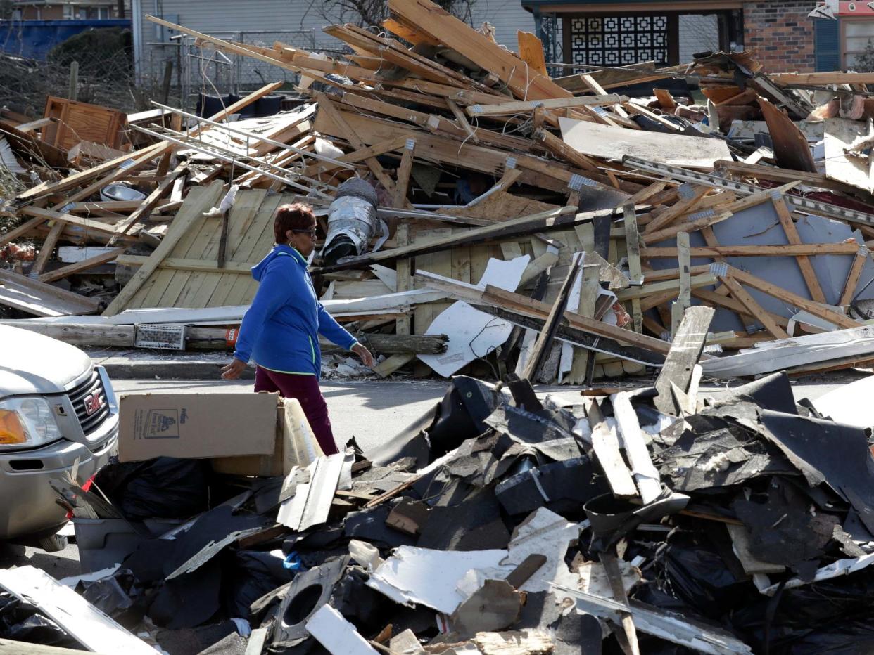 A woman walks down a street lined with debris in Nashville after tornadoes hit the state: AP