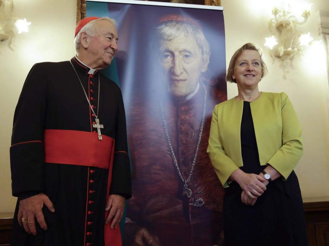 Cardinal Vincent Nichols and Sally Jane Axworthy, the British Ambassador to the Holy See, stand in front of picture of Cardinal John Henry Newman ahead of his upcoming canonisation: AP