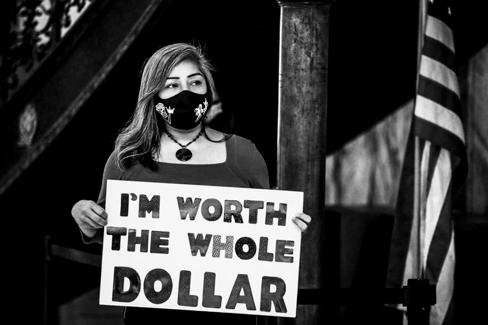 Jackie Ortiz, co founder of The Pay Equity Coalition and councilmember on the Rochester City Council, holds a sign during a a press conference on Aug. 13, 2020 in Rochester, N.Y. (Tina MacIntyre-Yee / Rochester Democrat and Chronicle / via USA TODAY Network)