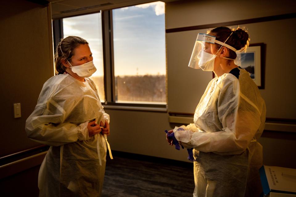 Nurses Stephenie Simmons and Emily Owen wear protective gowns, masks and face shields as they prepare to check on a COVID-19 patient at Mary Greeley Medical Center in Ames on Friday, Jan. 7, 2022.