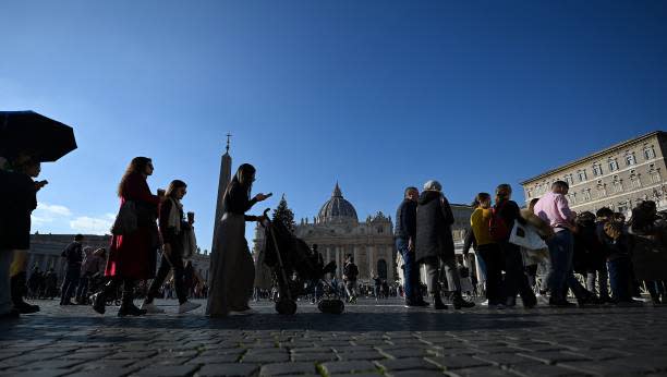 Visitors walk by St Peter’s Square at The Vatican on 28 December 2022 (AFP via Getty Images)