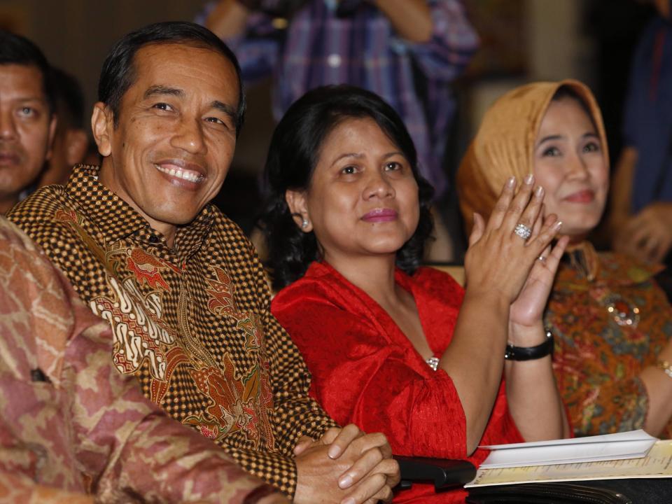 Indonesian President Joko Jokowi Widodo and his wife Iriana react as names are read out during their son's graduation ceremony at Anglo-Chinese School in Singapore