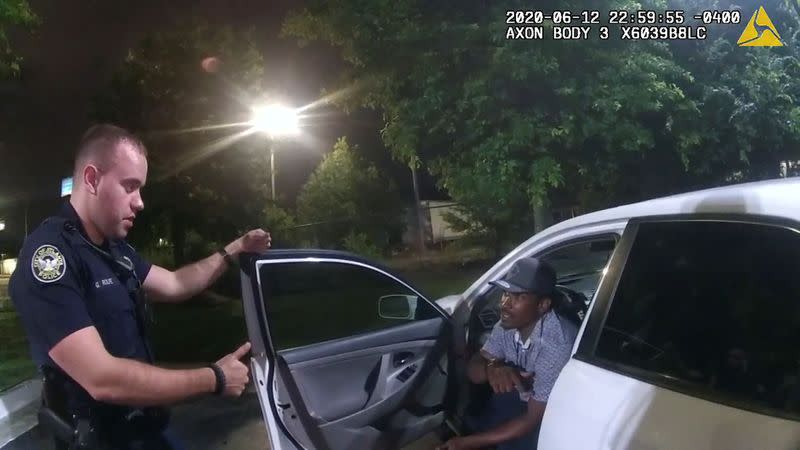 Former Atlanta Police Department officer Garrett Rolfe questions Rayshard Brooks in a Wendy's restaurant parking lot