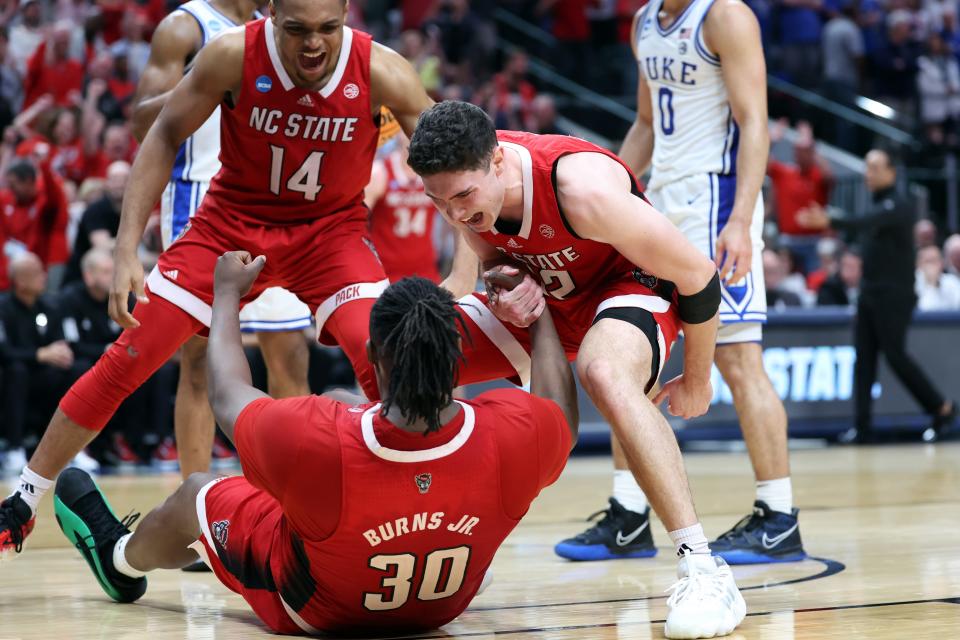 Mar 31, 2024; Dallas, TX, USA; North Carolina State Wolfpack guard Michael O'Connell (12) reacts with forward DJ Burns Jr. (30) and guard Casey Morsell (14) in the second half against the Duke Blue Devils in the finals of the South Regional of the 2024 NCAA Tournament at American Airline Center. Mandatory Credit: Kevin Jairaj-USA TODAY Sports