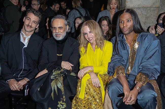 Kylie Minogue and three men sat at fashion show