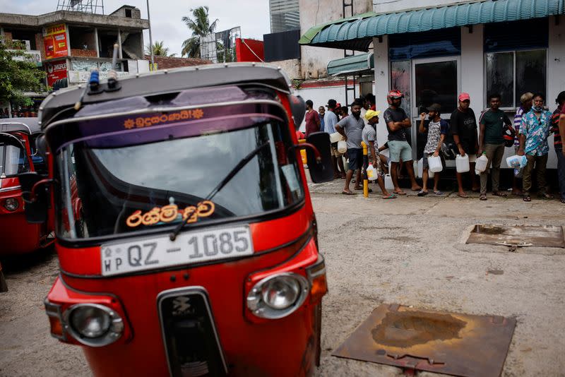 People wait in a queue to buy petrol at a fuel station, amid the country's economic crisis in Colombo