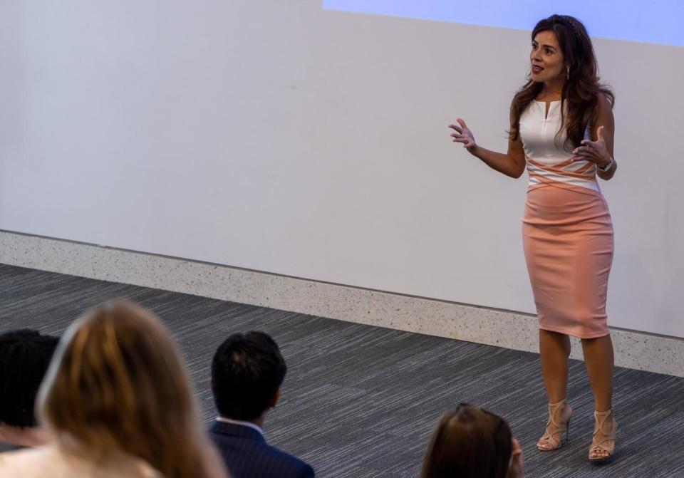 A woman addresses a group in an auditorium.