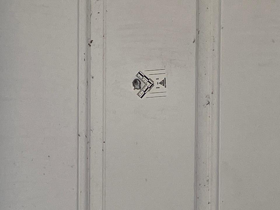 Neighbors said sheriff's deputies marked this door that shows a hole that came from a gun, fired from inside a residence that killed a woman on Friday night.