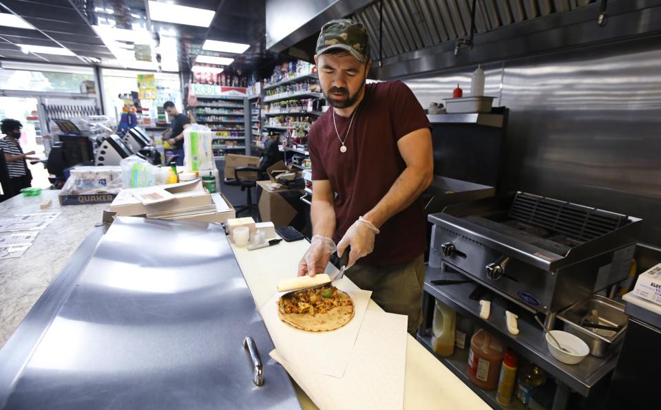 Jay Mohammad piles on the chicken and vegetables as he makes a Chicken Gyro at Jay's Kitchen, located inside Henry's Convenience Market in Rochester Wednesday, Aug. 2, 2023.
