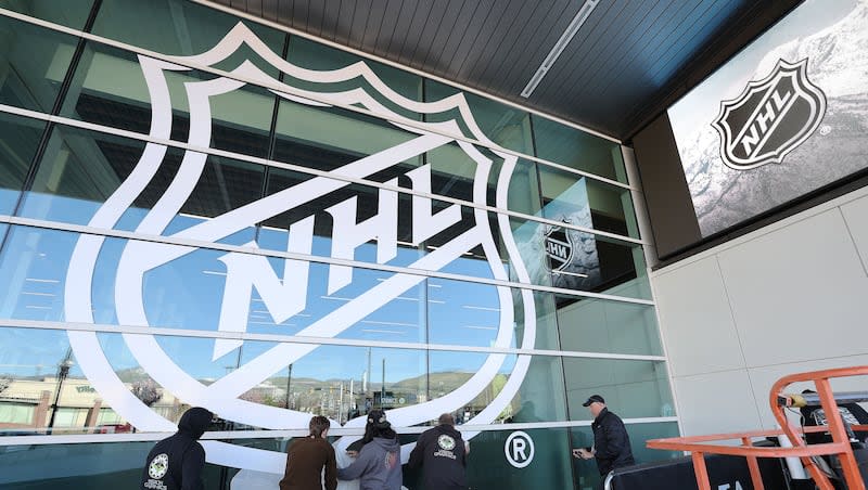 Vision Graphics crews install an NHL banner on the Delta Center in Salt Lake City on Thursday, April 18, 2024. Jazz owner Ryan Smith bought the Arizona Coyotes and they will relocate to Salt Lake City.