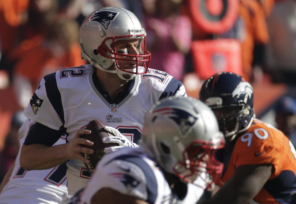 New England Patriots quarterback Tom Brady (12) looks for an opening to pass during the first half of the AFC Championship NFL playoff football game against the Denver Broncos in Denver, Sunday, Jan. 19, 2014. (AP Photo/Charlie Riedel)