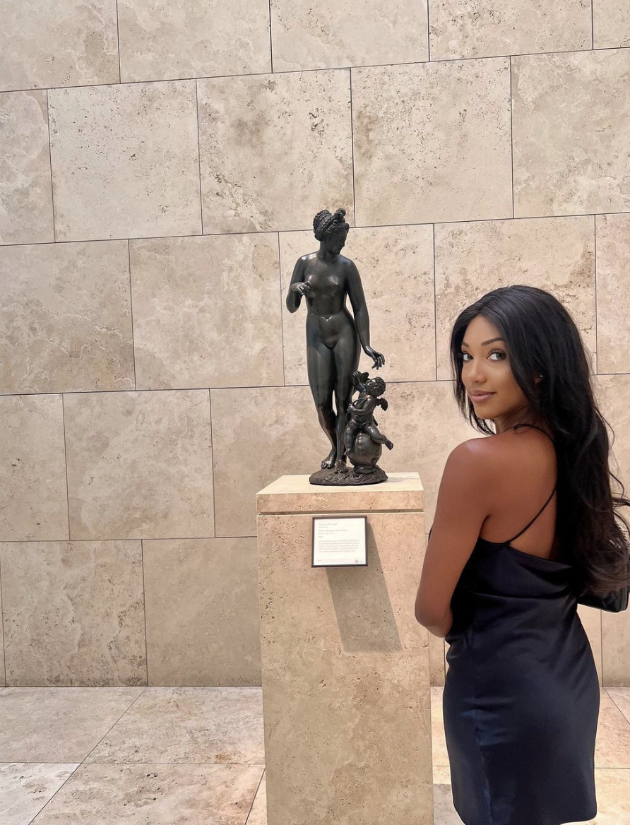 a person posing next to a statue