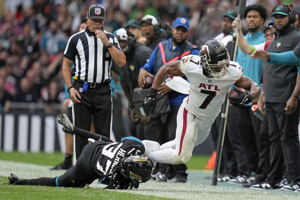 Atlanta Falcons running back Bijan Robinson (7) is tackled by Jacksonville Jaguars cornerback Tre Herndon (37) during the third quarter of an NFL football game between the Atlanta Falcons and the Jacksonville Jaguars at Wembley stadium in London, Sunday, Oct. 1, 2023. (AP Photo/Kirsty Wigglesworth)