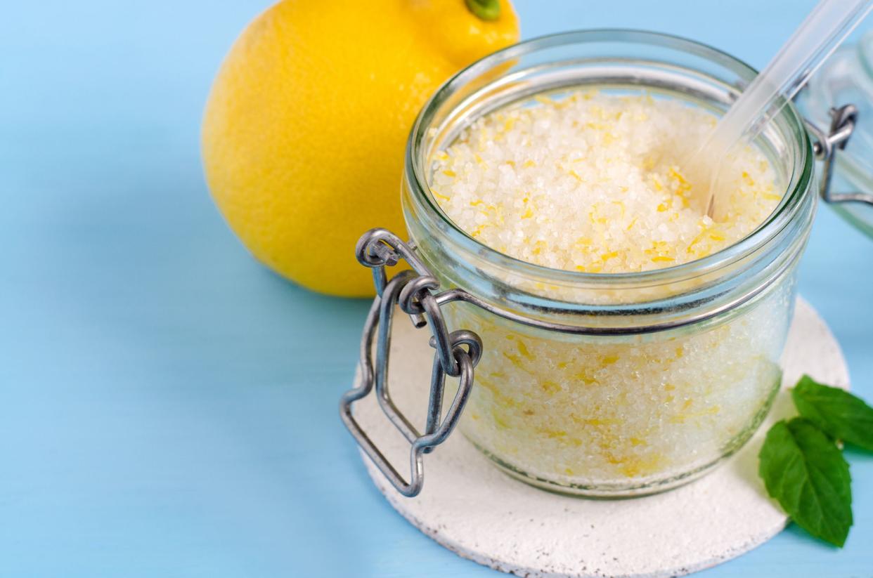 Homemade sugar scrub with olive oil, essential lemon oil and lemon peel. Diy cosmetics.  Copy space.