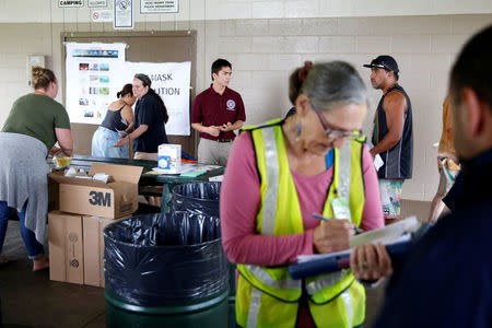 People line up for free dust masks in Keaau to protect themselves from volcanic ash during ongoing eruptions of the Kilauea Volcano in Hawaii, U.S., May 17, 2018. REUTERS/Terray Sylvester