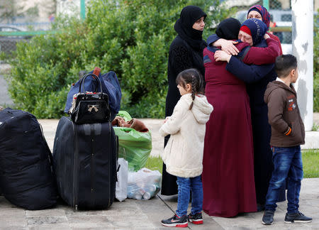 A Syrian refugee girl stands near luggage of Syrian refugees returning to Syria, in Beirut, Lebanon, December 6, 2018. Picture taken December 6, 2018. REUTERS/Jamal Saidi