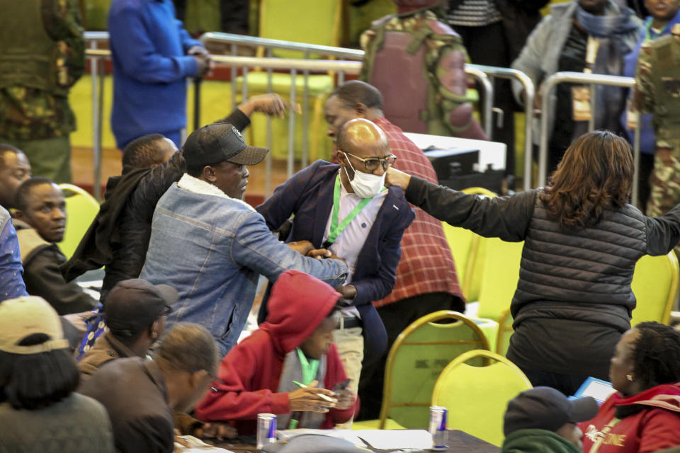 Scuffles break out between political party agents and police at the electoral commission's national tallying center in Nairobi, Kenya late night Saturday, Aug. 13, 2022. Kenya's peaceful presidential election saw a brief disruption late Saturday when police responded to scuffles at the national tallying center amid tensions over the close results. (AP Photo)