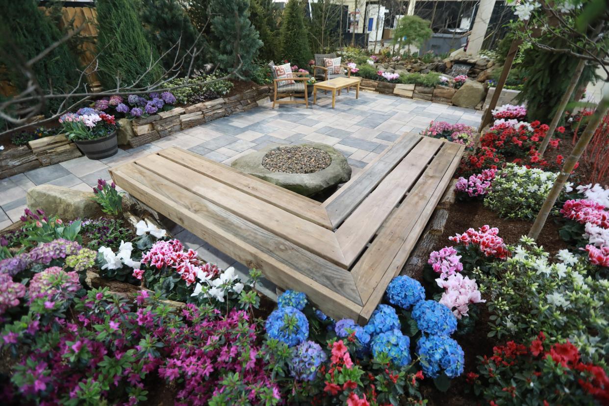 At the 2021 Home & Garden Show, Oakland Nurseries' Rustic Spring Getaway garden has an outdoor-seating area with extensive plantings and a waterfall.