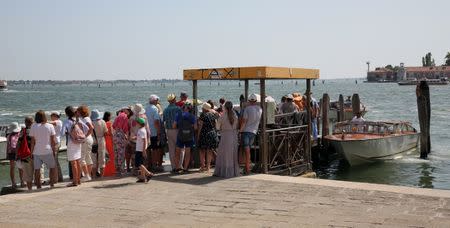 Tourists waits on queue at the taxi boat near St.Mark's square in Venice, Italy, August 3, 2017. Picture taken on August 3, 2017. REUTERS/Stefano Rellandini