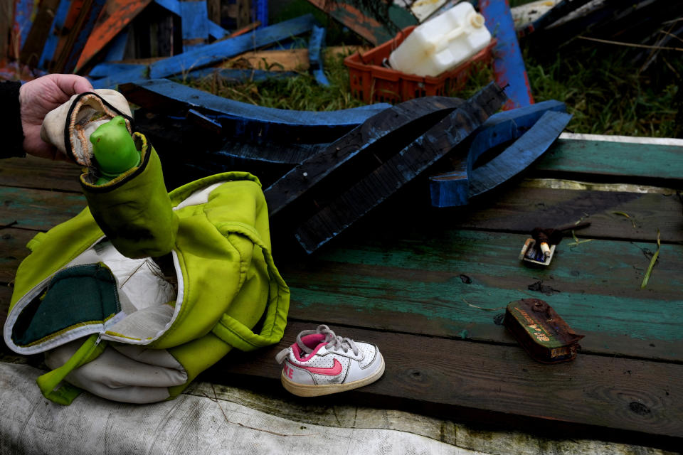 Milan's Opera maximum security prison inmate Andrea Volonghi checks personal belongings left in a wrecked migrants' boat stored in the prison facilities, near Milan, northern Italy, Friday, Feb. 9, 2024. Inmates at Opera used the wood of wrecked boats sailed by migrants across the Sicily Channel to craft the musical instruments that the 'Sea Orchestra' used during their debut at La Scala Opera House in Milan on Monday, Feb. 12, 2024. The violins, violas and cellos played by the Orchestra of the Sea in its debut performance Monday at Milan's famed Teatro all Scala carry with them tales of hardship. (AP Photo/Antonio Calanni)