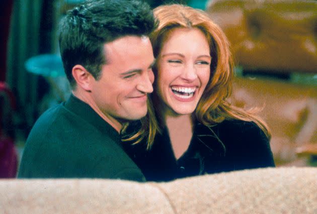 Actor Matthew Perry and actress Julia Roberts hug each other on the set of 