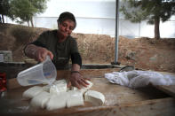 In this photo taken Wednesday Dec. 11, 2019, Aphrodite Philippou, 73, makes Cyprus' halloumi cheese at a farm in Kampia village near Nicosia, Cyprus. Cyprus' halloumi cheese, with a tradition dating back some five centuries, is the island nation's leading export. It's goat and sheep milk content makes it a hit with health-conscious cheese lovers in Europe and beyond. It's added appeal is that unlike other cheeses, it doesn't melt when heated up. (AP Photo/Petros Karadjias)