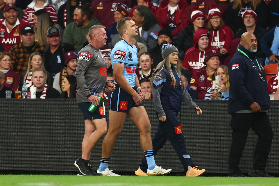 BRISBANE, AUSTRALIA - JUNE 21:  Tom Trbojevic of the Blues is assisted of the field after an injury during game two of the State of Origin series between the Queensland Maroons and the New South Wales Blues at Suncorp Stadium on June 21, 2023 in Brisbane, Australia. (Photo by Chris Hyde/Getty Images)