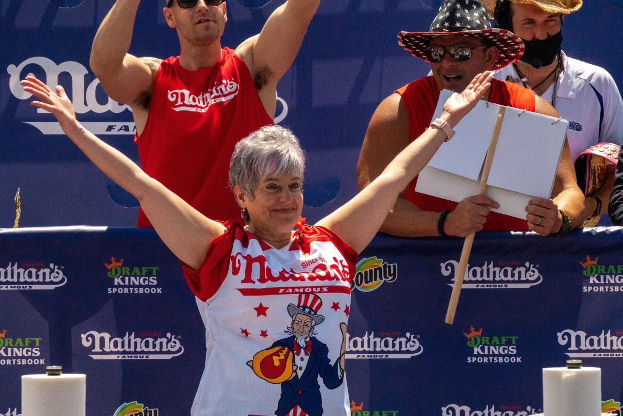 Competitive eater and third-place winner Larell Marie Mele raises her hands at the 2021 Nathan's Famous 4th Of July International Hot Dog Eating Contest on July 4, 2021, in New York City.