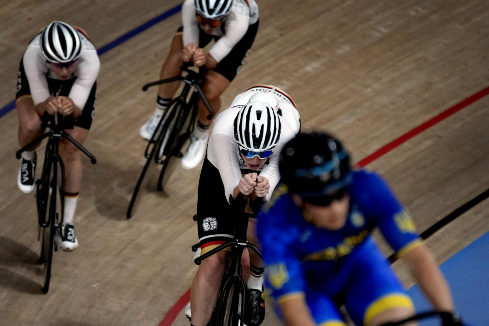 Members of the German and Ukraine men's track cycling team round the track during a training session inside the Izu velodrome at the 2020 Summer Olympics, Thursday, July 29, 2021, in Tokyo, Japan. (AP Photo/Christophe Ena)