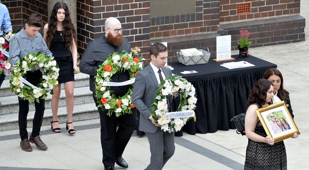 The mourners carried the wreaths in a procession after the funeral service on Wednesday. Photo: AAP