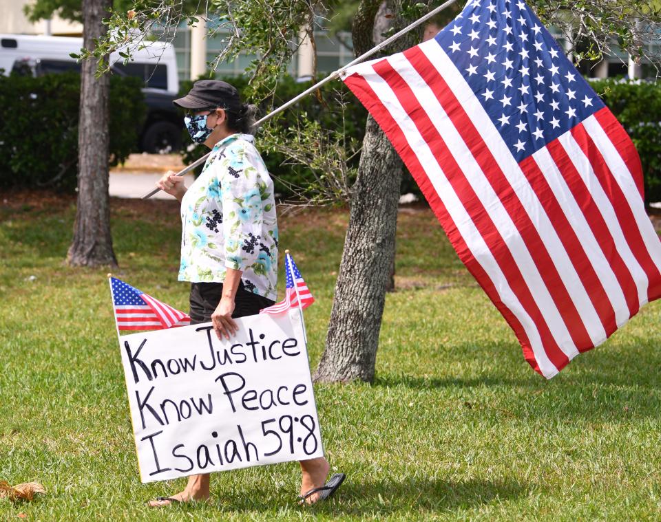 A demonstrator marches near the Moore Justice Center in Viera.