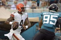 Cleveland Browns quarterback Deshaun Watson (4) looks for a receiver as he is pressured by Jacksonville Jaguars defensive end Roy Robertson-Harris (95) during the first half of an NFL preseason football game, Friday, Aug. 12, 2022, in Jacksonville, Fla. (AP Photo/Phelan M. Ebenhack)