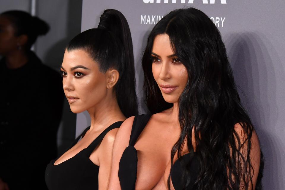 Kim and Kourtney Kardashian posing at an event