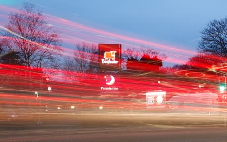 FILE PHOTO: Cars leave light trails as they pass a Premier Inn hotel in Liverpool