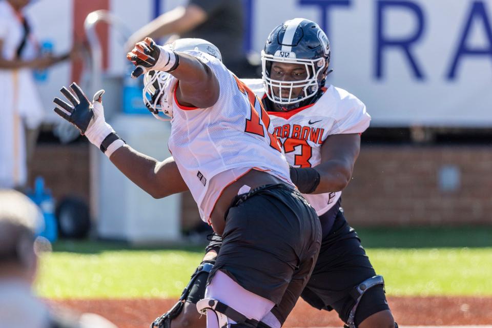 Jan 30, 2024; Mobile, AL, USA; American offensive lineman Christian Haynes of Uconn (63) faces off against American offensive lineman Christian Jones of Texas (70) during practice for the American team at Hancock Whitney Stadium.