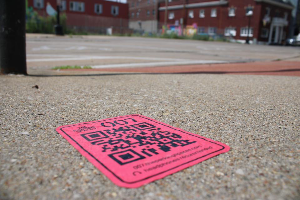 A QR code for "The Parking Spaces" located on the sidewalk in front of the Iowa City Senior Center off Linn Street.