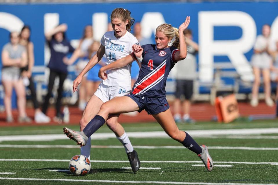 Providence Day defender Lauren Jensen (4) battles Latin forward Mary Schleusner in the first half in Charlotte, N.C., Saturday, May 15, 2021.