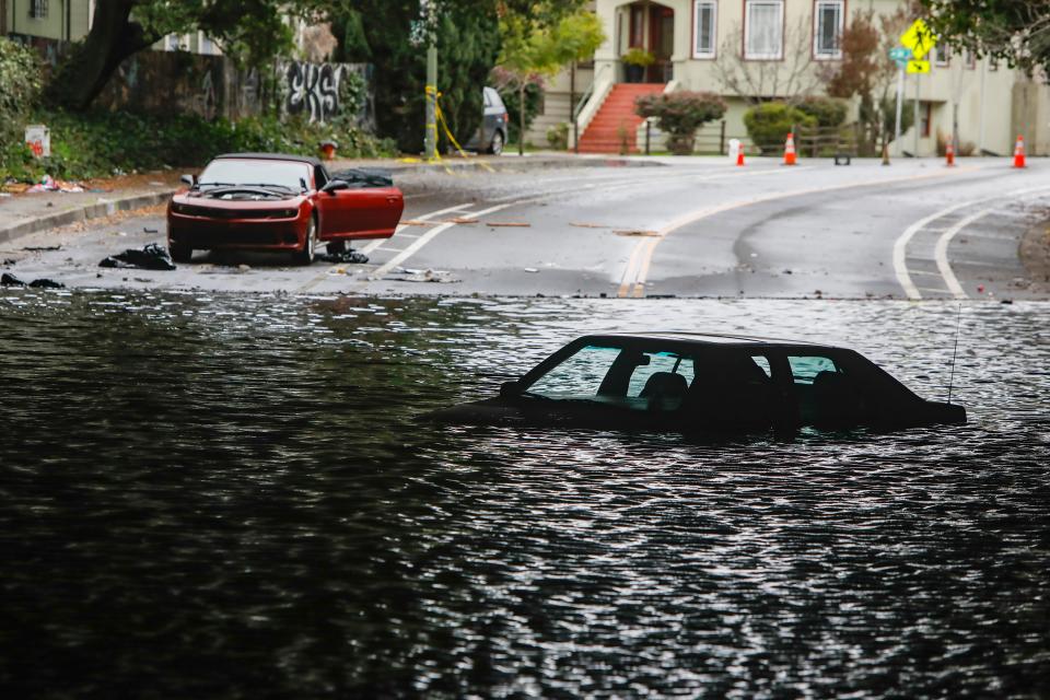 Cars sit stuck in a flooded underpass in Oakland, Calif., on Wednesday, January 4, 2023.