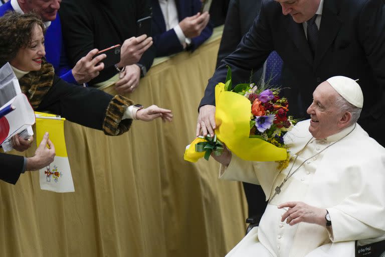 El papa Francisco recibe flores durante la audiencia general semanal en el Aula Pablo VI en el Vaticano, 15 de febrero de 2023