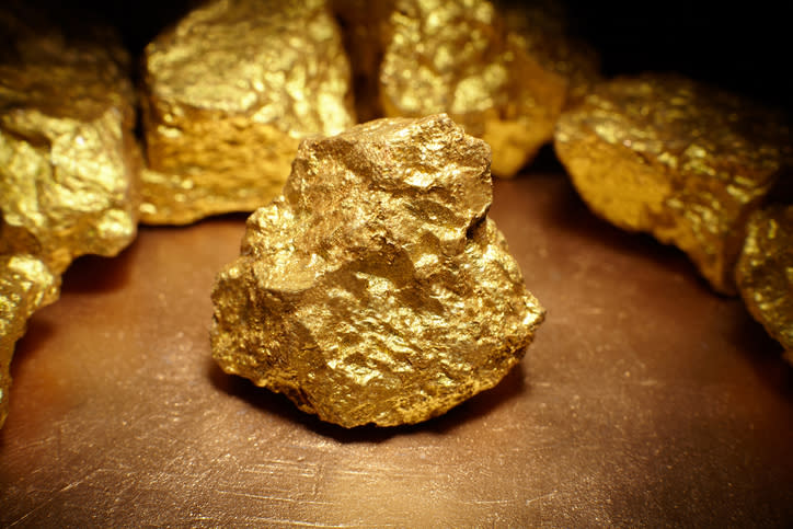 Gold nuggets arranged in a circle on a table.